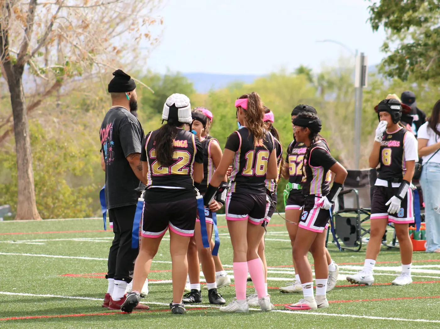 Vegas Girls athletes gathered in a team huddle