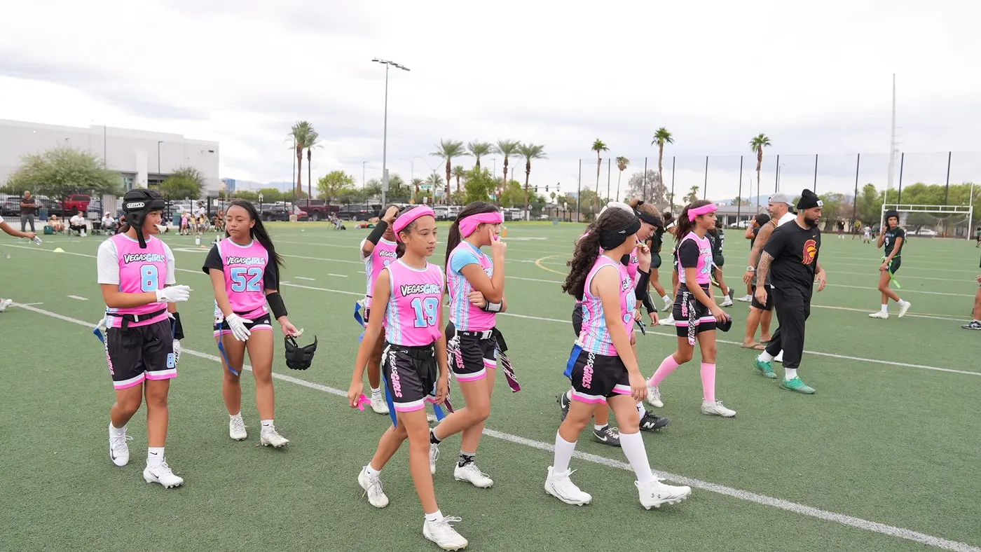 Vegas Girls athletes crossing the field in pink uniforms